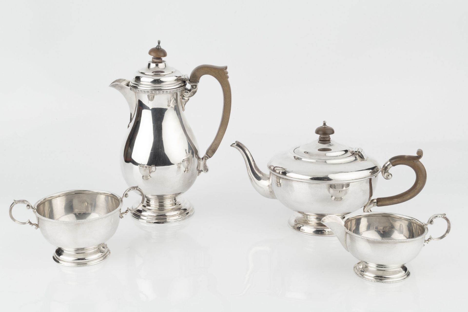 A George V silver three piece tea service, with beaded borders, the teapot with composite handle and - Bild 2 aus 2