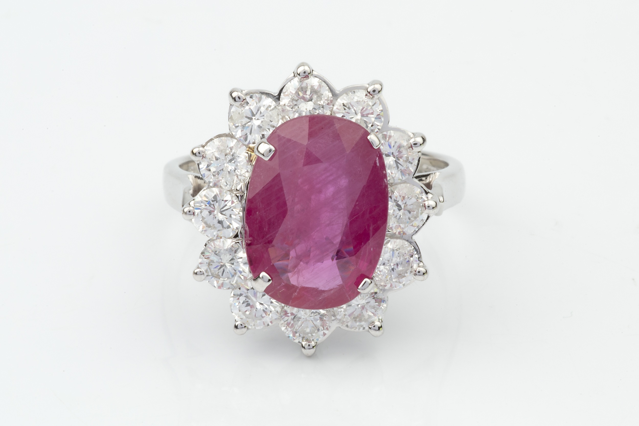 A ruby and diamond cluster ring, the oval mixed cut ruby within a border of twelve round brilliant - Image 3 of 4