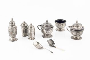 A George V silver three piece cruet set, relief decorated with stylised foliage and having reeded