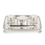 A late Victorian silver inkstand, of rectangular gadrooned form, having central oval hinged lidded