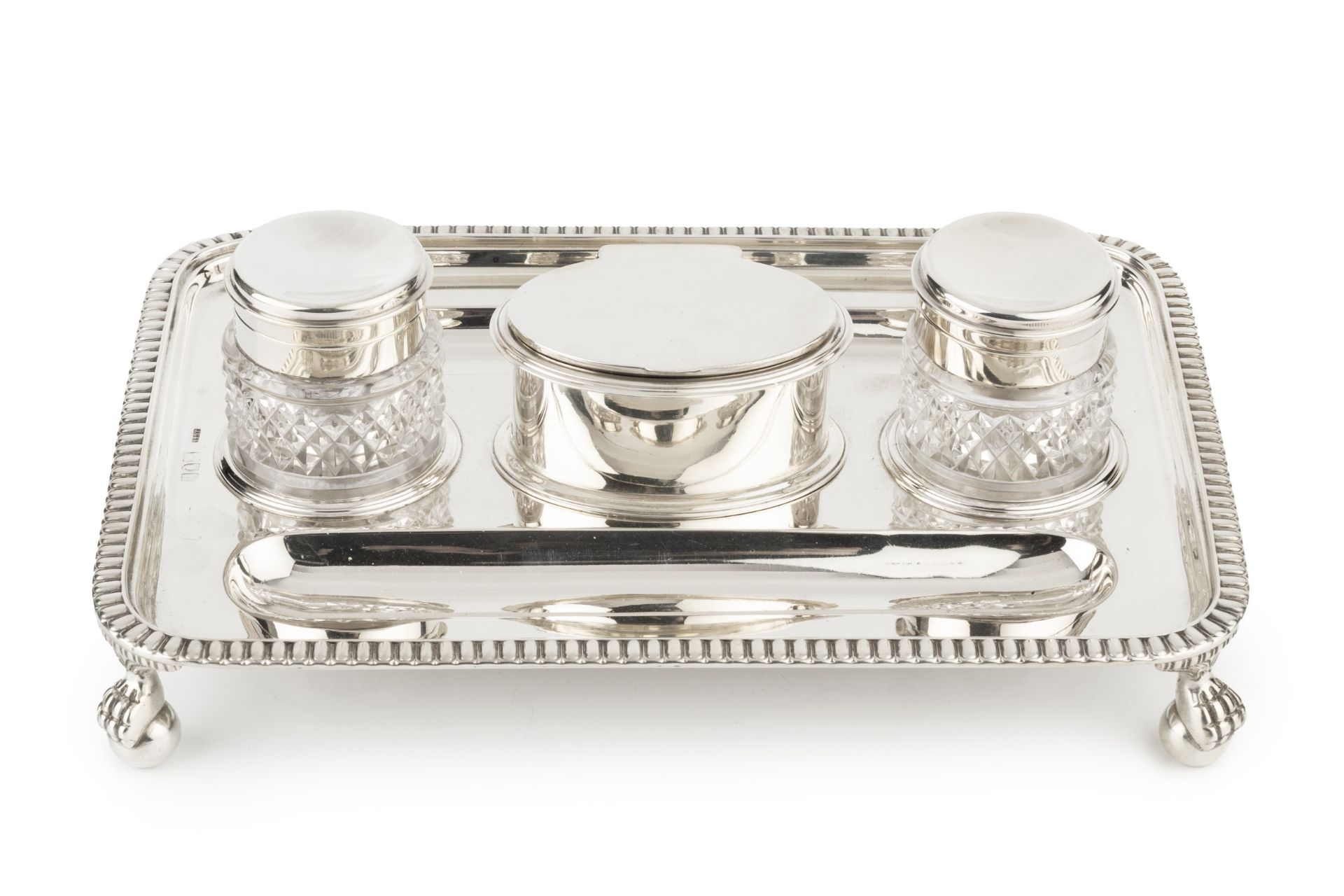 A late Victorian silver inkstand, of rectangular gadrooned form, having central oval hinged lidded