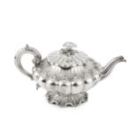 A William IV silver teapot, of lobed and compressed form, with shaped and engraved scalloped borders