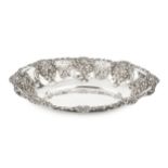 An Edwardian silver oval dish, repoussé decorated with scallops, flowers and foliage, and with