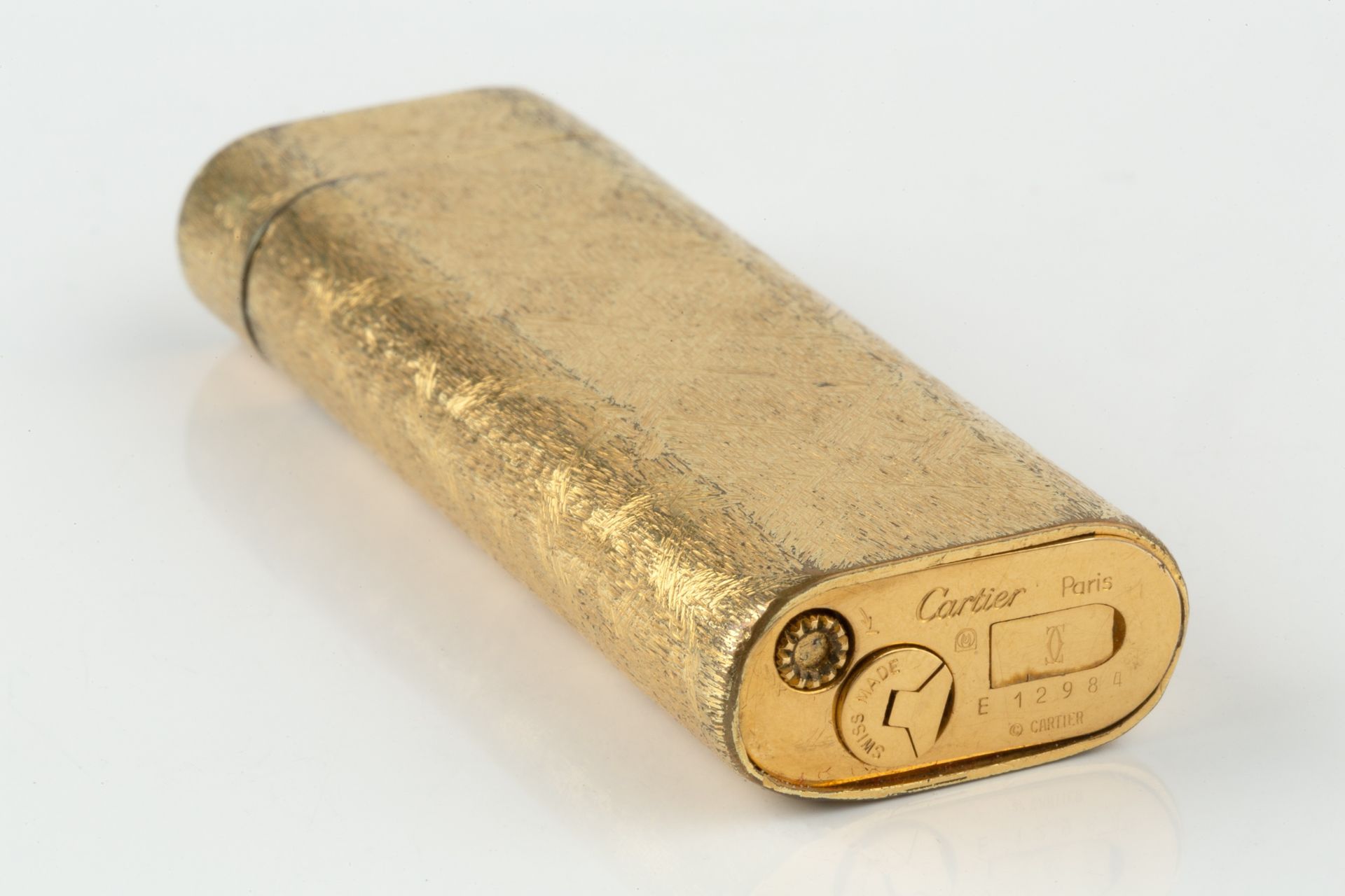 A gold plated lighter by Cartier, of rounded rectangular form and having textured decoration, no. - Bild 3 aus 3