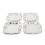 A set of four George III Irish silver serving dishes, of shaped square outline, having reeded and