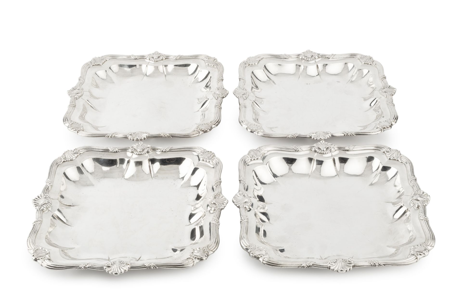 A set of four George III Irish silver serving dishes, of shaped square outline, having reeded and