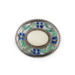 A silver and enamel Arts & Crafts style oval brooch, centred with a pale cabochon opal within a
