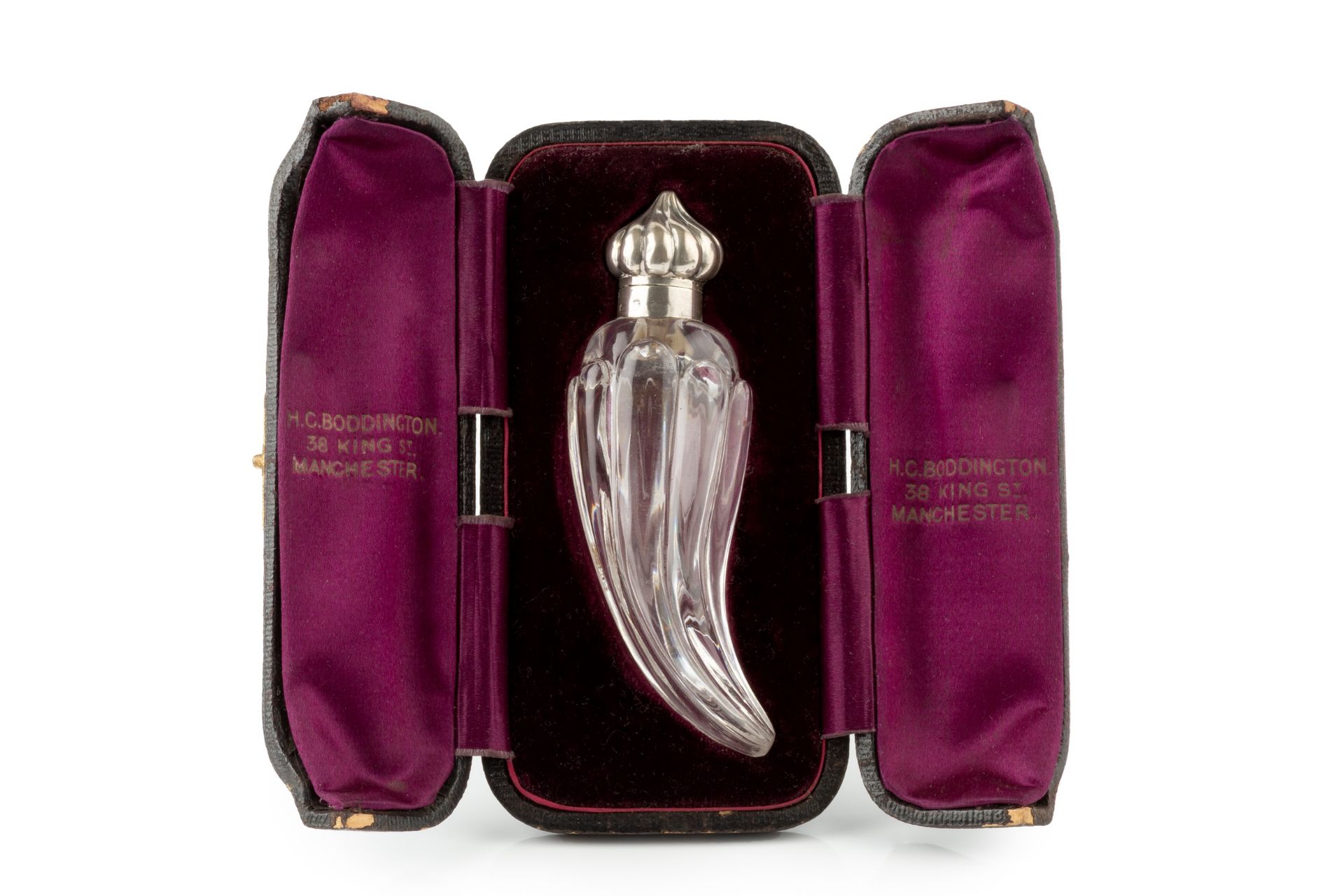 A late Victorian silver mounted glass scent bottle, of curved and lobed form, the hinged domed and