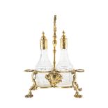 A George III silver-gilt cruet stand, the central foliate loop handle flanked by two gadrooned