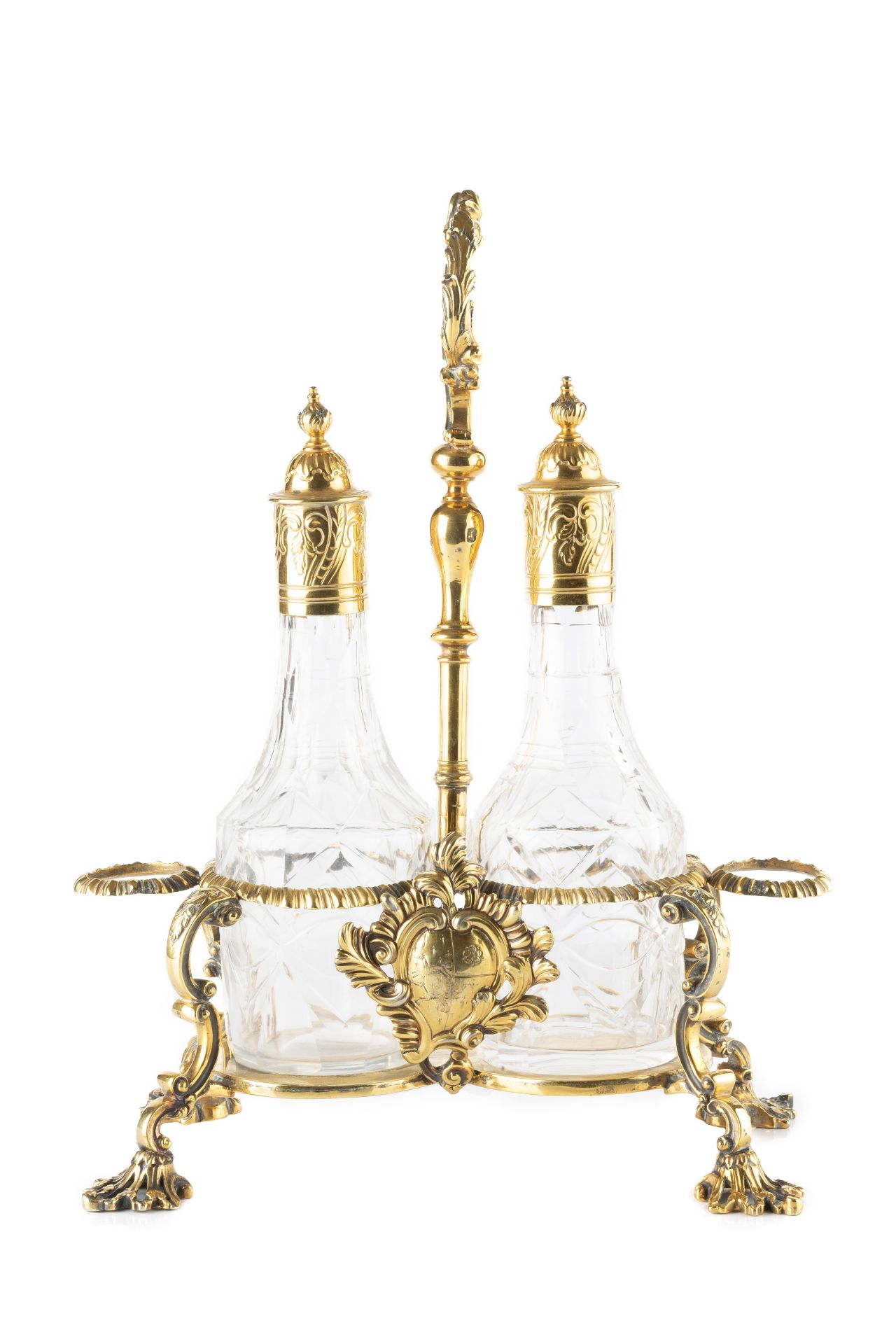 A George III silver-gilt cruet stand, the central foliate loop handle flanked by two gadrooned