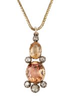 A topaz and diamond pendant, formed from oval orange and slightly smaller orange-brown stones