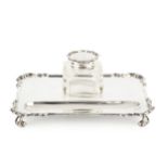 A George V silver inkstand, of shaped rectangular form, fitted with a single square section cut