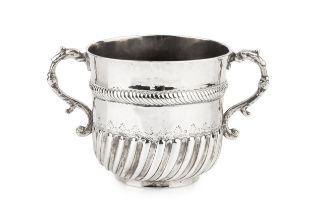 A William III silver porringer, the girdled body with spirally lobed lower section, and having