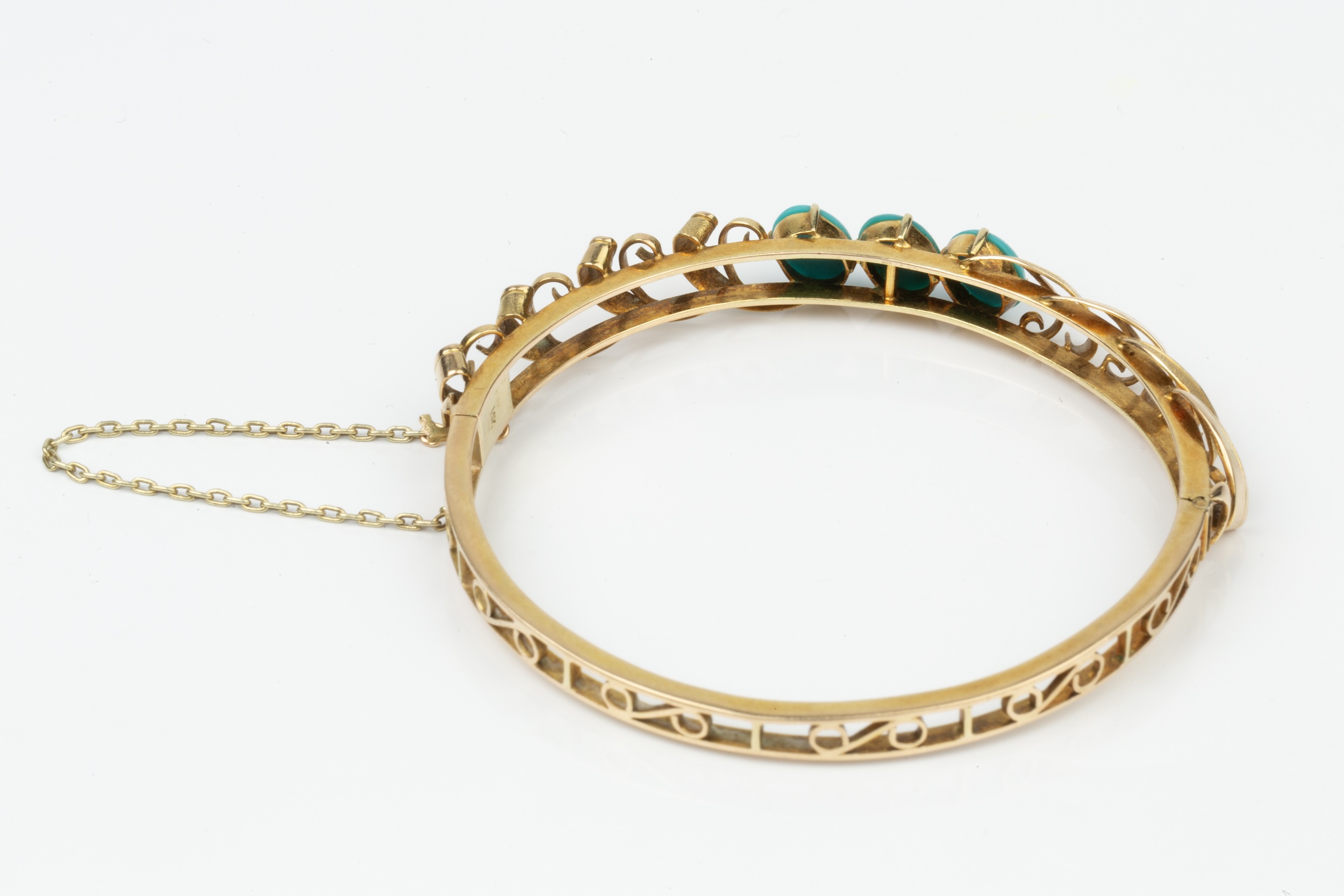 A 14K gold hinged bangle, with pierced decoration and set with three oval cabochon turquoise, and - Image 2 of 2