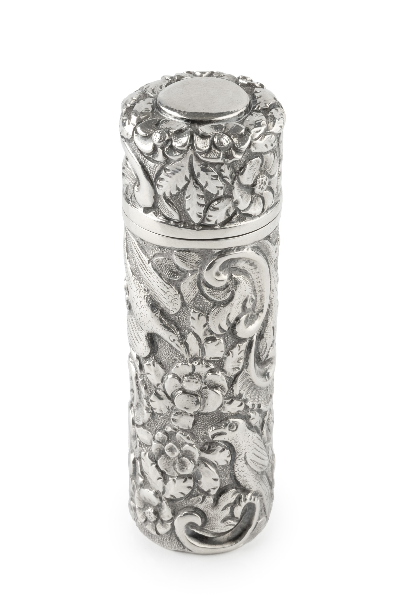 A late Victorian silver scent bottle of cylindrical form, embossed and engraved with exotic birds