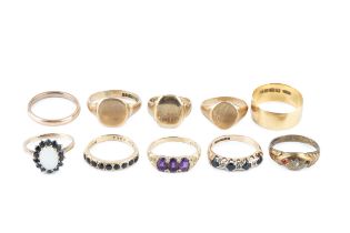 An 18ct gold wedding band, a 9ct gold wedding band, and three 9ct gold signet rings, together with