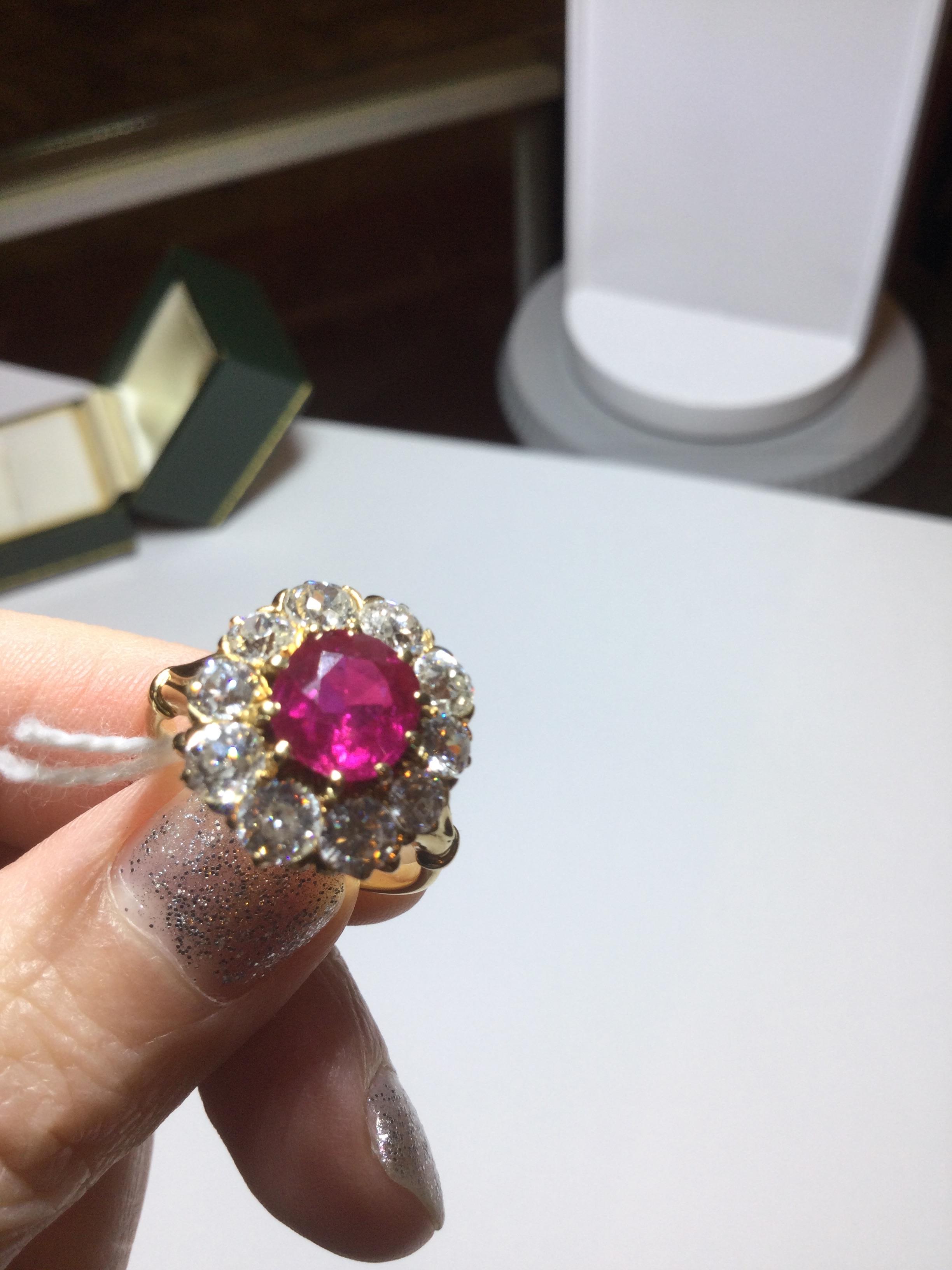A ruby and diamond cluster ring, the central oval cut ruby within a border of ten old brilliant - Image 11 of 14