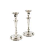 A pair of silver candlesticks, with reeded borders and knopped faceted stems, on circular weighted