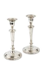 A pair of silver candlesticks, with reeded borders and knopped faceted stems, on circular weighted