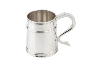 A silver pint mug, the tapered girdled body with reeded borders, and having shaped handle,