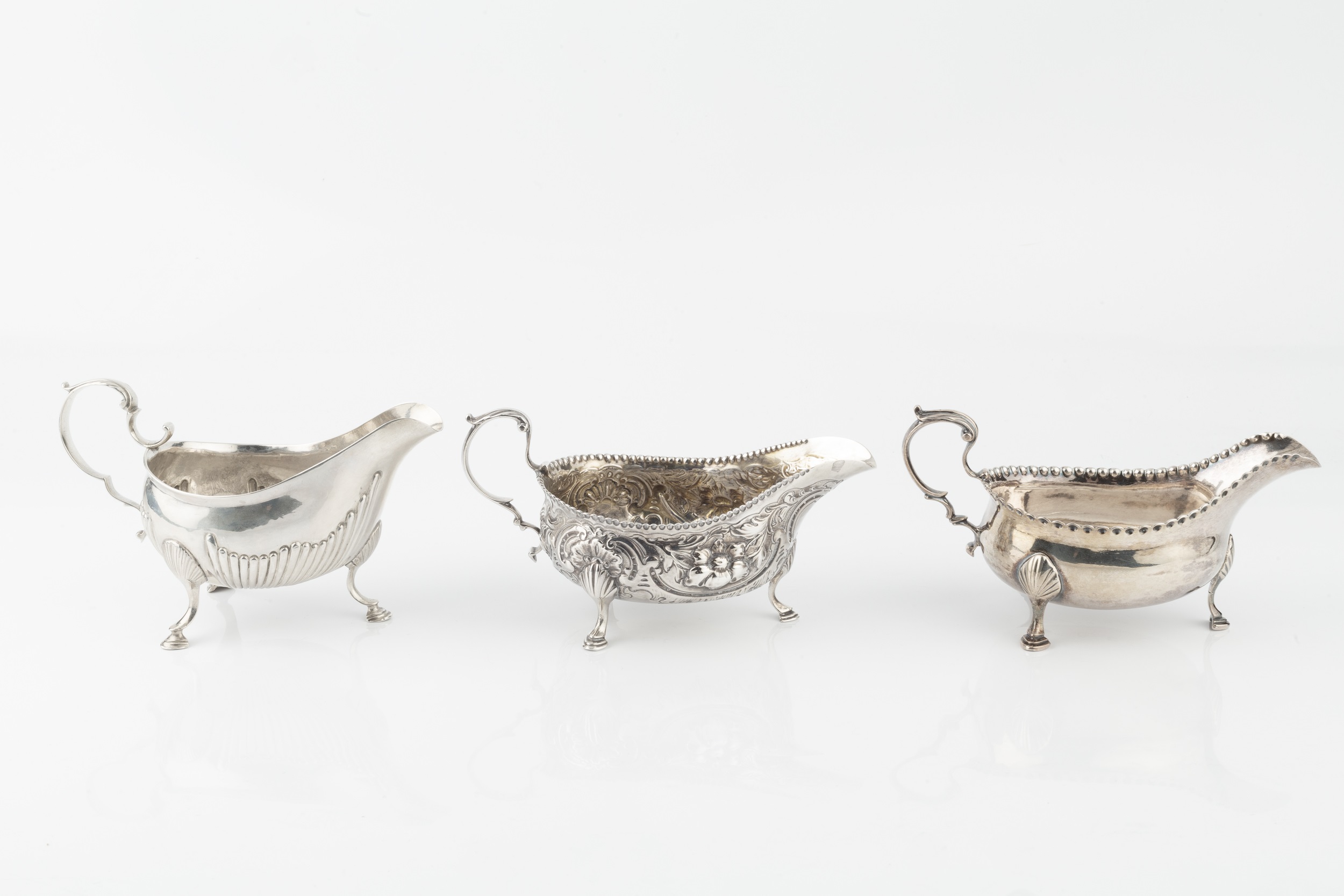 A George III silver sauce boat, with punched border and leaf capped scroll handle, on pad feet by - Image 2 of 3