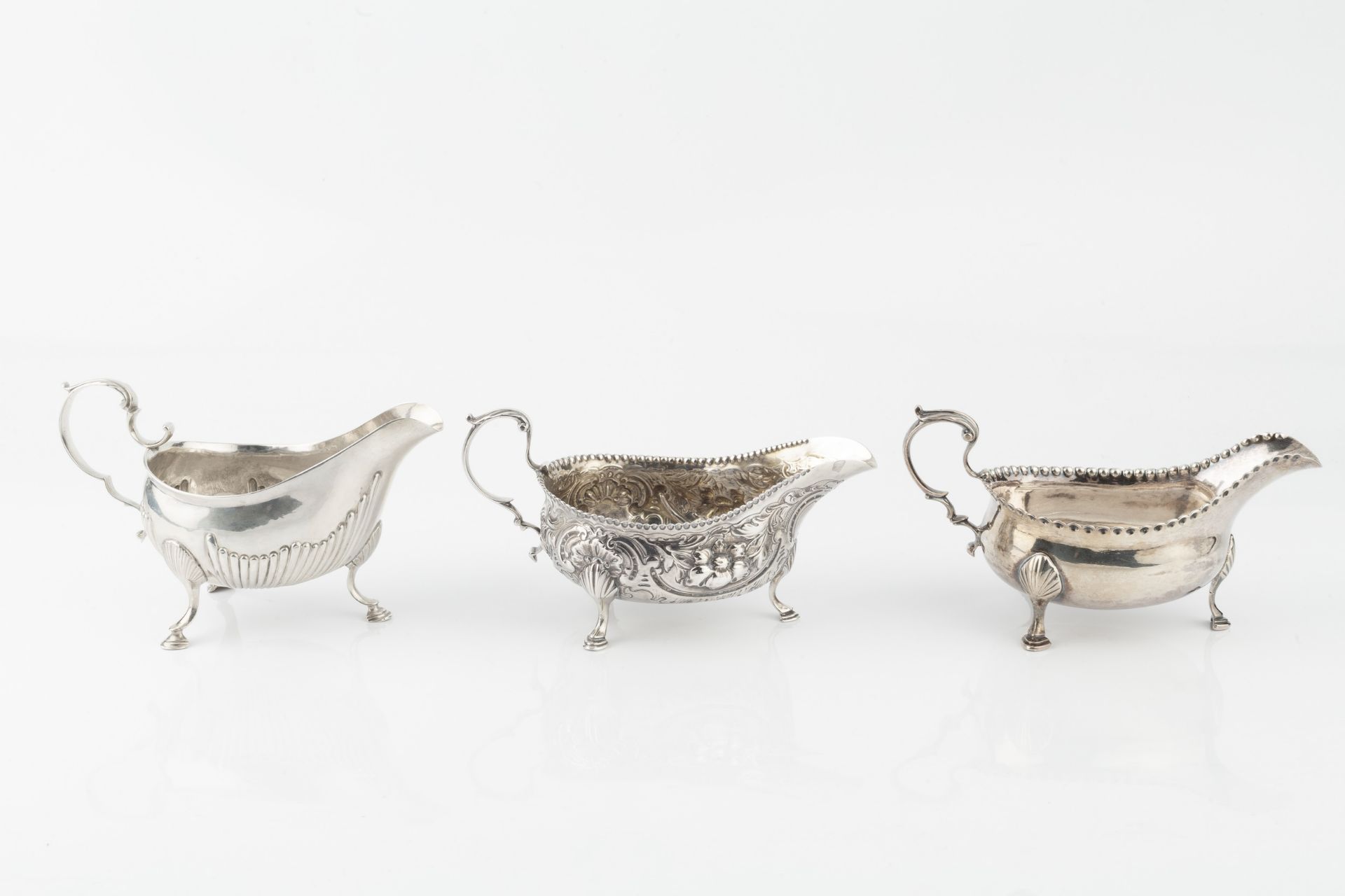A George III silver sauce boat, with punched border and leaf capped scroll handle, on pad feet by - Bild 2 aus 3