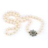 A single strand uniform cultured pearl necklace, with diamond and emerald set white precious metal