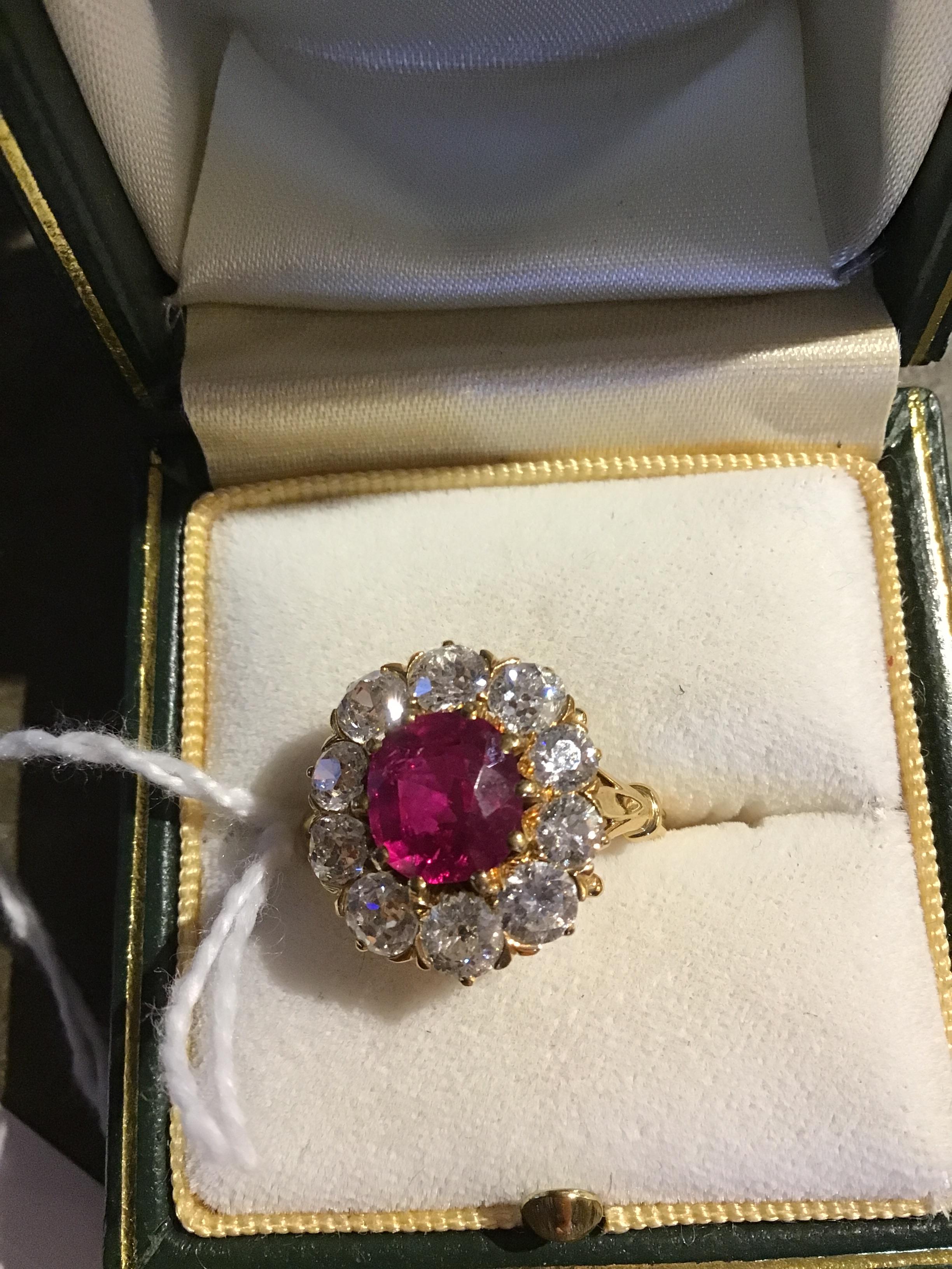 A ruby and diamond cluster ring, the central oval cut ruby within a border of ten old brilliant - Image 6 of 14
