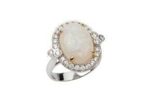 An opal and diamond dress ring, the oval cabochon opal of approx 5.2ct within a border of round
