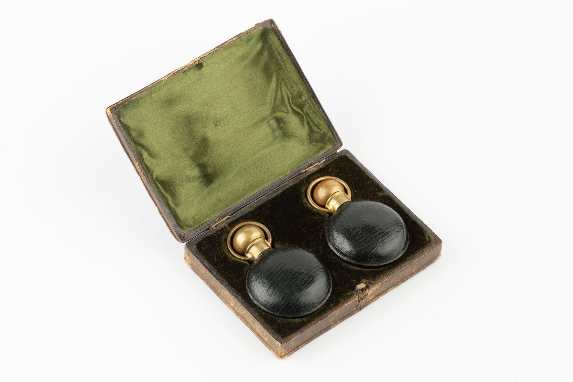 A pair of late Victorian green leather cased scent bottles, with gilt metal mounts, 6cm high in