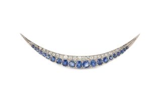 A sapphire and diamond crescent brooch, set with a line of twenty-one graduated cornflower-blue