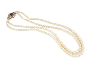 A twin strand graduated cultured pearl necklace, with shaped 9ct gold clasp centred with a red stone