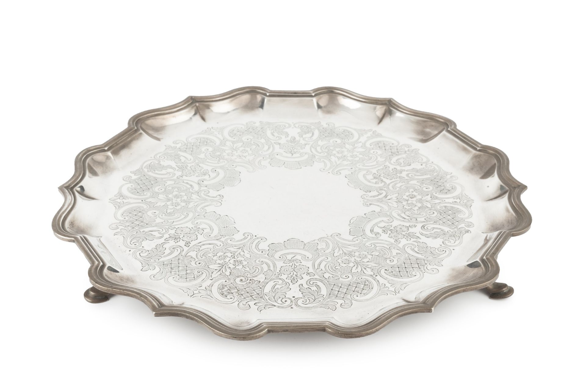 A George V silver salver, with shaped border, engraved with flowers and stylised scrolling
