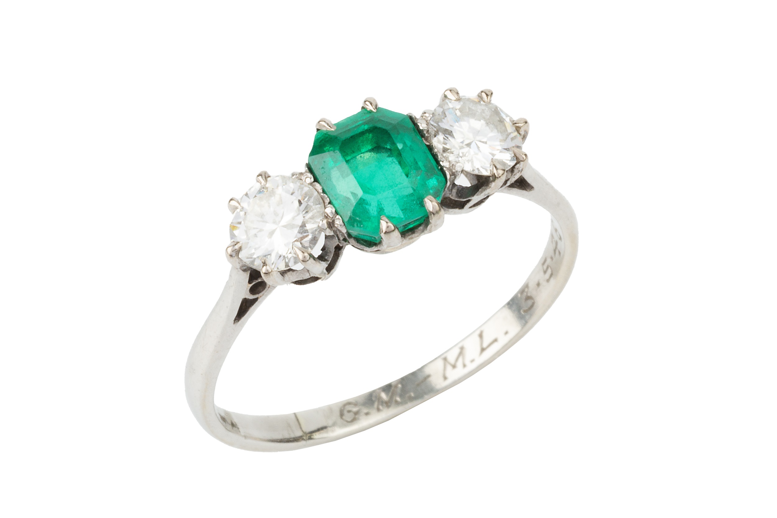 An emerald and diamond three stone ring, the emerald cut centre stone of approx 1.1ct flanked by a