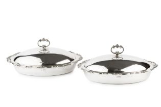 A pair of Edwardian silver oval entree dishes and covers, with beaded scroll cast borders and loop