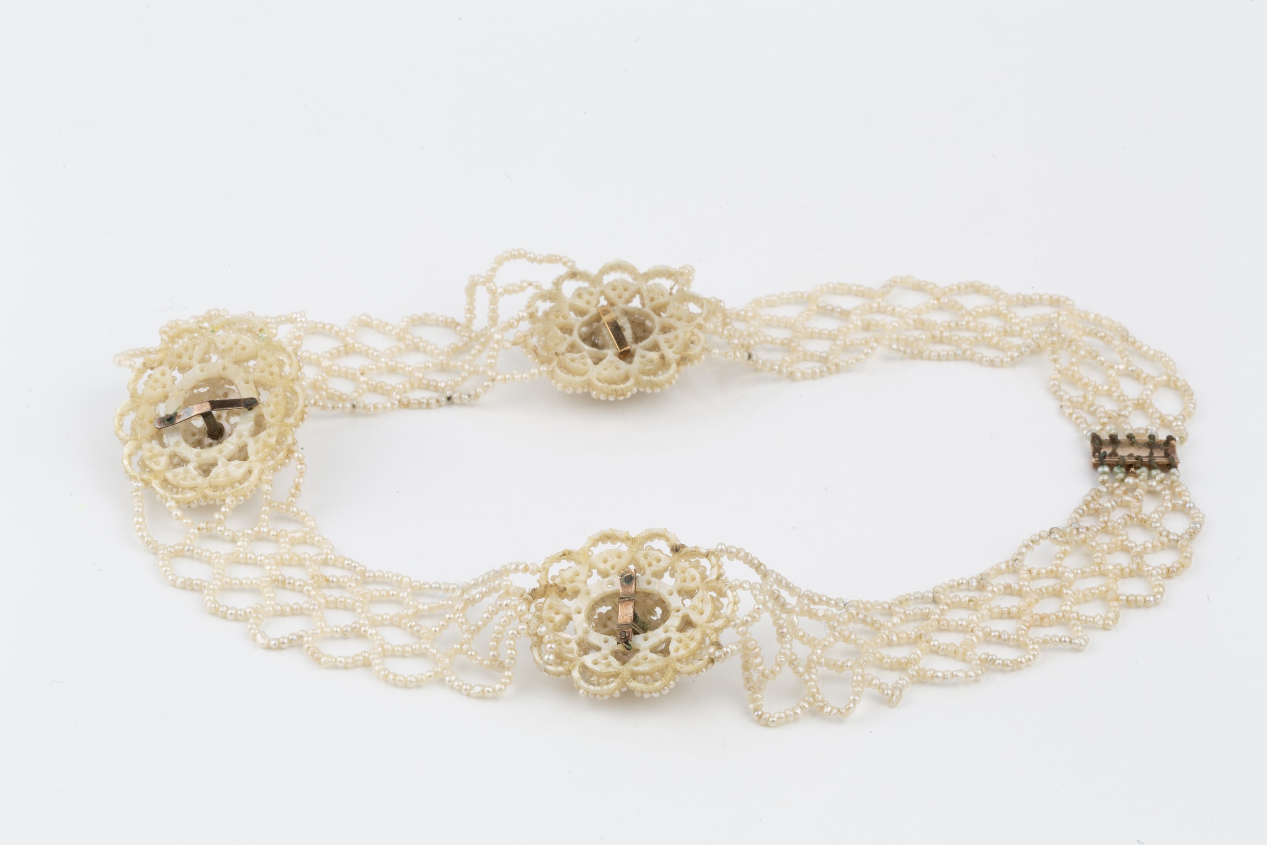 An early 19th century seed pearl collar, comprising three mother of pearl panels with raised - Image 2 of 2