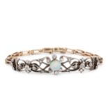 An opal and diamond set panel bracelet, featuring ornate arabesque scroll work in white metal,