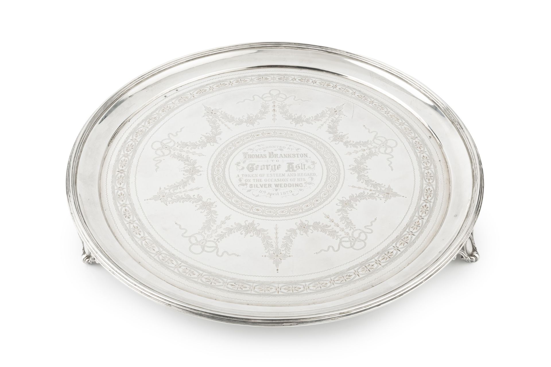 A late Victorian silver circular salver, with reeded border and engraved with garlands of ribbon