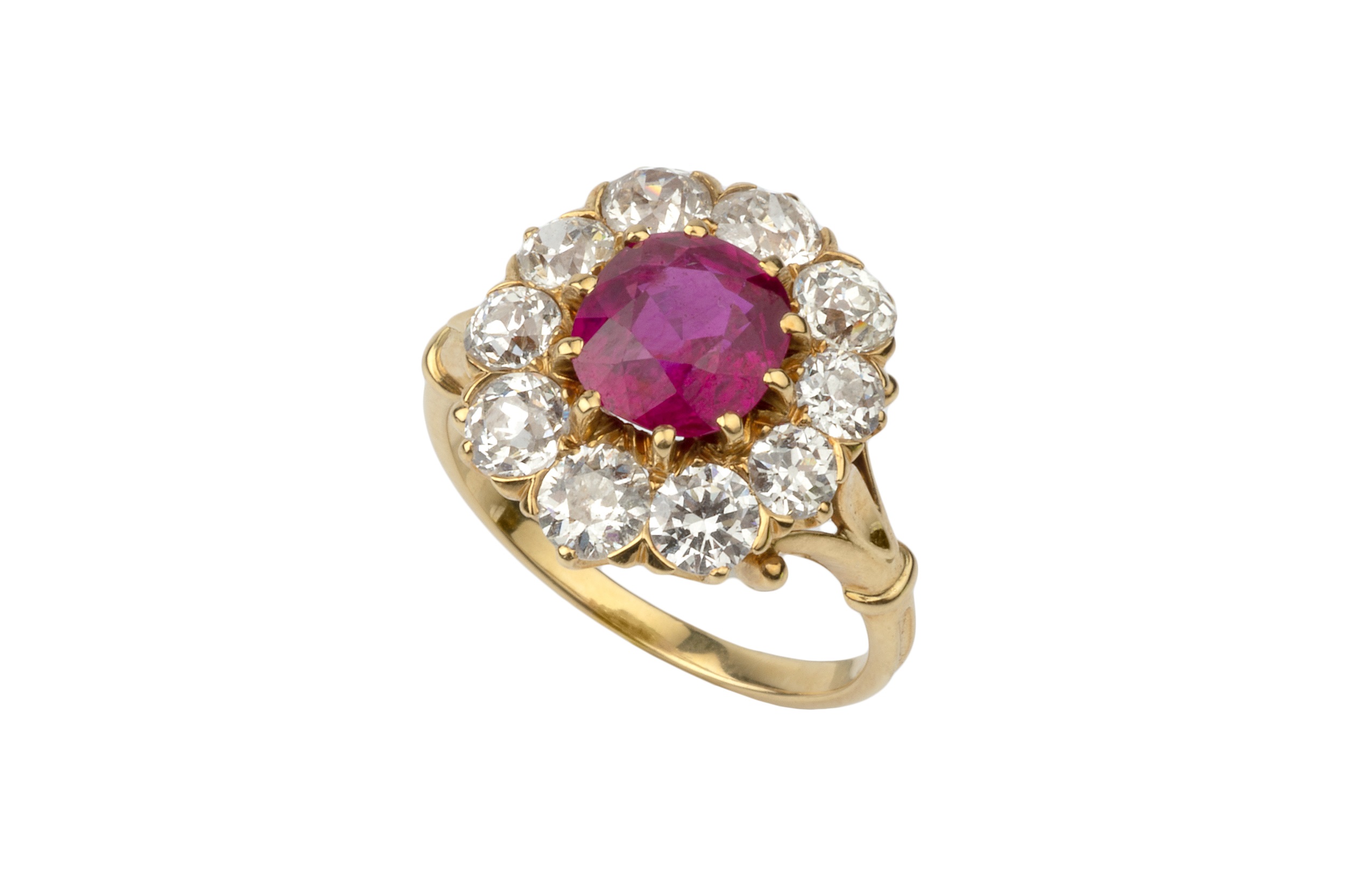 A ruby and diamond cluster ring, the central oval cut ruby within a border of ten old brilliant