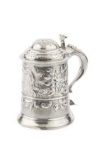 A George III silver tankard, the girdled body and domed hinged cover later embossed with flowers and