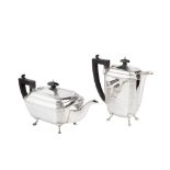 A George V silver teapot and matching hot water pot, of chamfered rectangular form engraved with