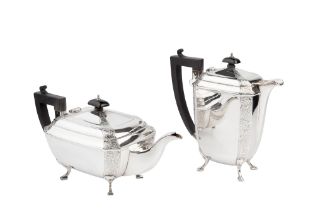 A George V silver teapot and matching hot water pot, of chamfered rectangular form engraved with