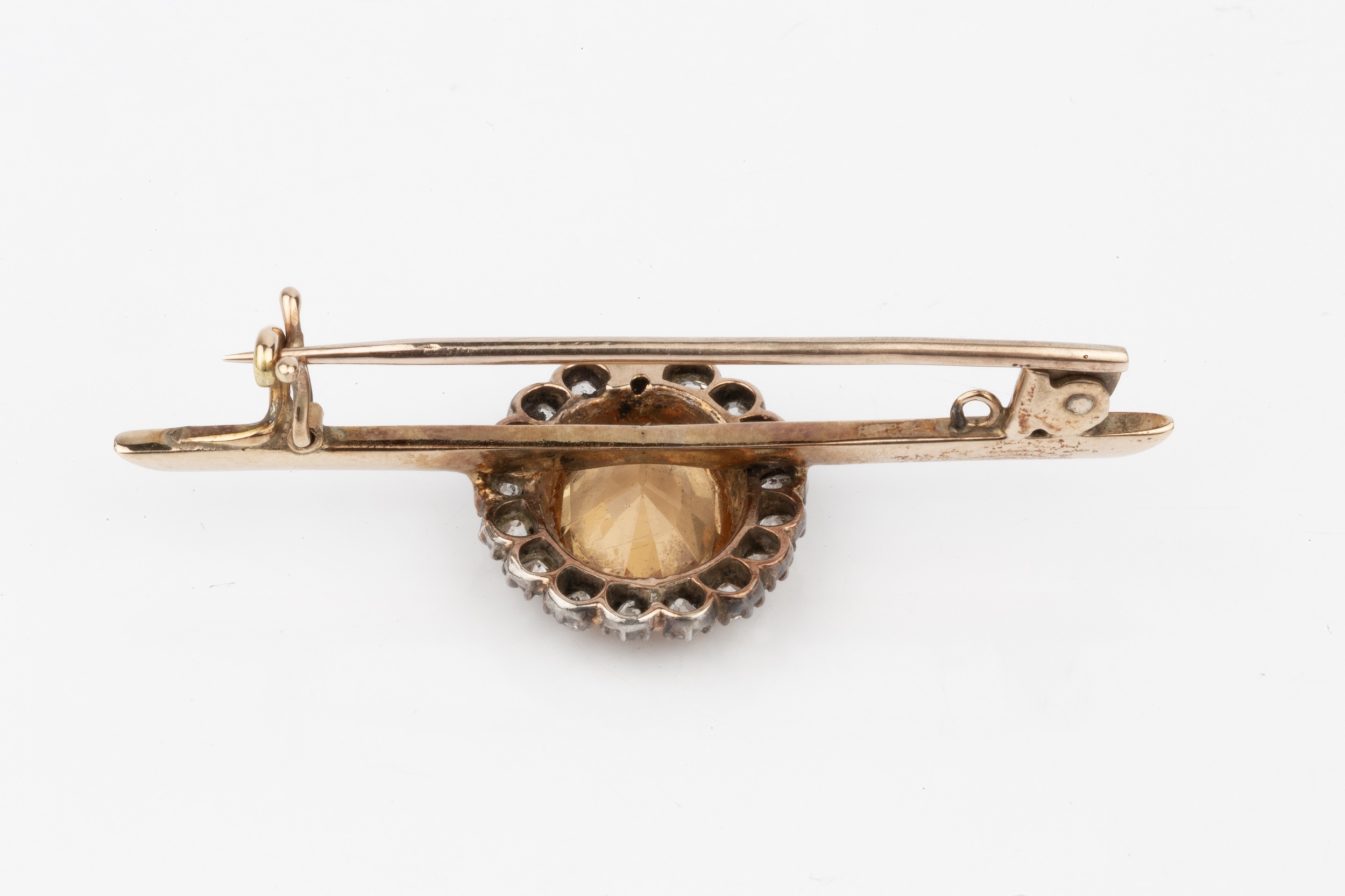 A topaz and diamond mounted bar brooch, the oval orange-brown stone within a border of seventeen - Image 2 of 2