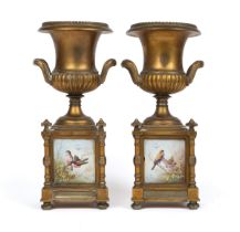 A pair of brass urns on square plinth bases