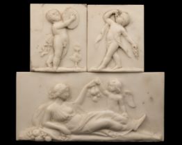 A marble tablet of Venus and Cupid together with a pair of marble plaques of putti