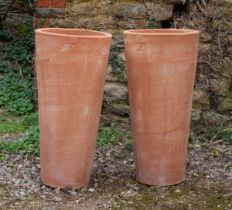 A pair of tall cylindrical Tuscan terracotta planters