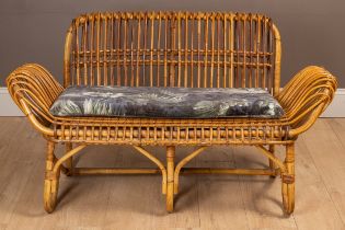 A wicker framed two-seater sofa