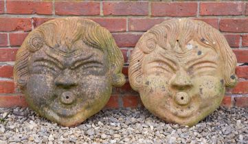 A pair of moulded terracotta masks for wall hanging