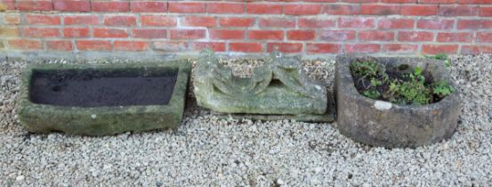 An old architectural element together with two stone troughs