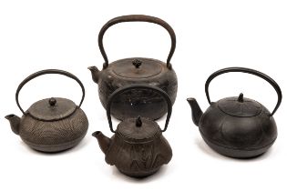A collection of four Japanese cast metal teapots